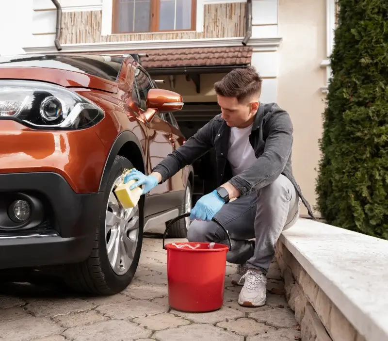 Lavage auto à domicile Arpajon-sur-Cère : professionnel intervenant sur un véhicule